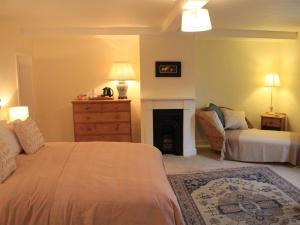 a bedroom with a bed and a couch and a fireplace at Church Farmhouse B & B in Kennett
