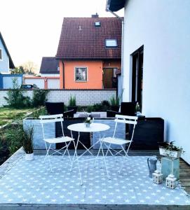 eine Terrasse mit einem Tisch und Stühlen sowie ein Haus in der Unterkunft Marie Antoinette in Schwandorf in Bayern