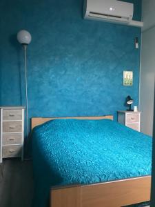 a bedroom with a bed with a blue wall at Leucate, maison dans village naturiste Eden à 50 m de la plage, 4 personnes in Leucate