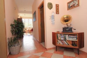 a hallway with a book shelf with books and a clock on the wall at Vila Mozara in Slano