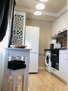 a kitchen with a table and a white refrigerator at The Classic Studio in Buzău