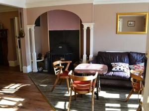 a living room with a couch and a table and chairs at The Sandrock Lynton in Lynton