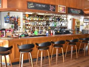 a bar with black stools in a restaurant at The Sandrock Lynton in Lynton
