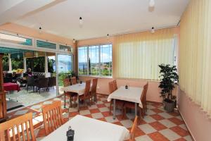 a restaurant with tables and chairs and a large window at Vila Mozara in Slano