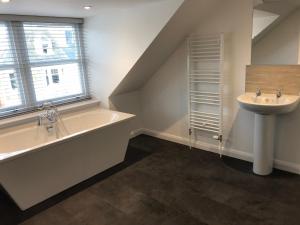 a bathroom with a tub and a sink and a window at Thistle House in Inverness +29 photos