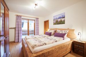 1 dormitorio con cama de madera y ventana en Landhaus Lina en Wallgau