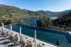 a swimming pool with chairs and a view of a lake at Vik Chile in San Vicente de Taguatagua