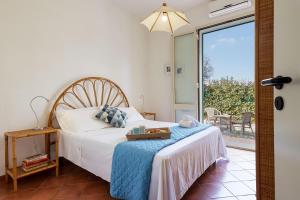a bedroom with a bed with a tray on it at Casa Vacanza Ondablu CaseSicule, on the Beach with big Veranda and Wifi in Santa Maria Del Focallo