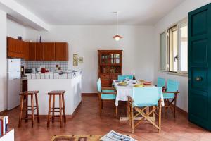 a kitchen with a table and chairs in a kitchen at Casa Vacanza Ondablu CaseSicule, on the Beach with big Veranda and Wifi in Santa Maria Del Focallo