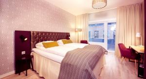 a hotel room with a large bed and a desk at Home Hotel Astoria in Hamar