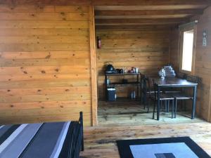 a room with a table and chairs in a cabin at Old Mill House Log Cabins in Dorchester
