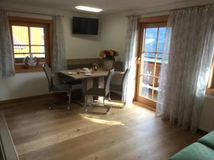 a dining room with a table and chairs and a window at Schröckhof in Stuhlfelden