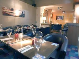 a restaurant with a table with wine glasses on it at Harty Costello Town House in Ballybunion