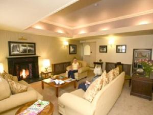 a living room with couches and a person sitting on a couch at Harty Costello Town House in Ballybunion