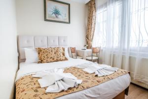 Un dormitorio con una cama con toallas blancas. en Camelot Apartment, en Estambul