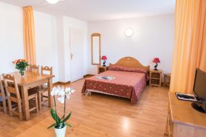 1 dormitorio con cama, mesa y comedor en Vacancéole - Résidence Le Birdie, en Giez