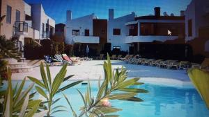 una piscina con sedie e sedie in un resort di T2 de luxo em Albur-VIllage a 10 minutos da praia a pé ad Alvor