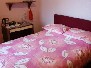 ブラックプールにあるLyndene Guest Houseのベッドルーム1室(花の飾られたピンクベッド1台付)
