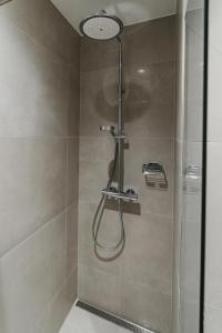 a shower with a shower head in a bathroom at ÖÖ Street Premium Apartment with Terrace in Tartu