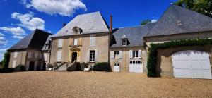 ein großes Haus mit zwei weißen Garagentüren in der Unterkunft Château de Mongazon in Saint-Franchy