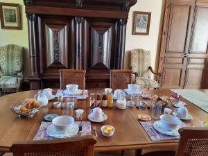 a wooden table with cups and dishes on it at Château de Mongazon in Saint-Franchy