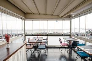 a dining room with tables and chairs and large windows at Camelot Apartment in Istanbul