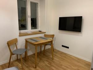 a room with a table and two chairs and a television at Piiri Apartment in Rakvere