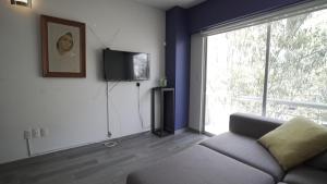 a living room with a couch and a large window at One Bedroom Apartment Del Valle in Mexico City