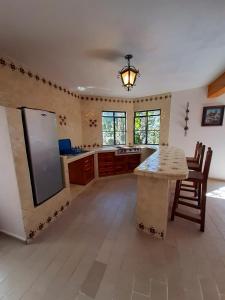 uma grande cozinha com um balcão e uma mesa em Hotel Posada San Javier em Taxco de Alarcón