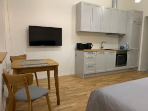a room with a kitchen with a table and a television at Piiri Apartment in Rakvere