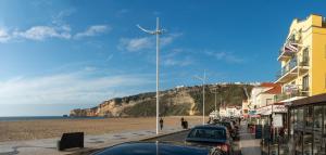 a car parked on the side of a beach next to the ocean at Hotel Oceano in Nazaré