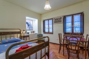 a bedroom with two bunk beds and a table and chairs at Hladik House - Alpi Giulie Cosy Apartment in Tarvisio