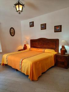 1 dormitorio con 1 cama grande con manta naranja en Hotel Posada San Javier, en Taxco de Alarcón