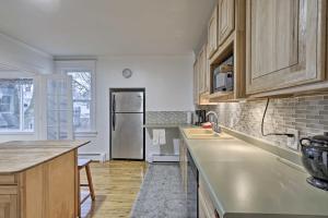 a kitchen with wooden cabinets and a stainless steel refrigerator at Charming Home Less Than One block to Lake Superior! in Ontonagon