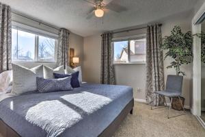 a bedroom with a bed and a chair and windows at Duplex with Private Yard 3 Mi to Downtown Loveland! in Loveland