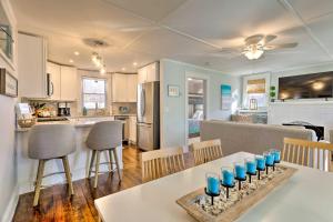 Cozy Coastal Cottage 5 Mi to Narragansett Beach! في ناراغانسيت: مطبخ وغرفة معيشة مع طاولة عليها أكواب زرقاء