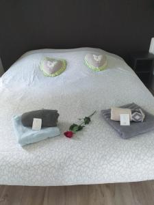 Una cama blanca con dos almohadas y flores. en Chalet De La Laigne en Allas-Bocage