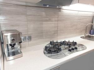 um balcão de cozinha com um fogão e comodidades para preparar café em Luxury Centre Located Apartment em Kiev