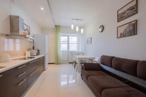 a kitchen and living room with a couch and a table at Апартаменты Петровские 90 кв в центре с хорошим видом in Tomsk