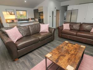 a living room with two brown couches and a table at Box Tree Escapes in Lancaster
