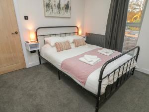 a bedroom with a bed with two towels on it at Box Tree Escapes in Lancaster