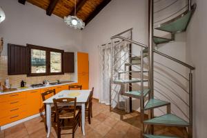 cocina con mesa y escalera de caracol en Casa Vacanze Cappuccini, en Castellammare del Golfo