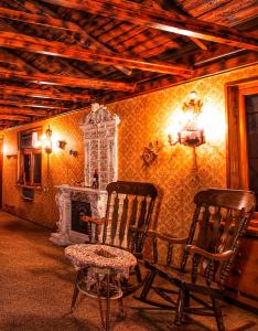 a room with two rocking chairs and a fireplace at Guest House Top Floor in Tʼelavi