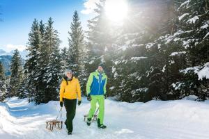 Twee mannen staan in de sneeuw op ski's. bij Hotel Central - das kleine Boutique Hotel am Achensee in Pertisau