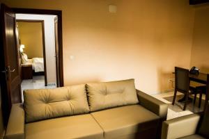 ein Wohnzimmer mit Sofa und Tisch in der Unterkunft Hôtel Jouvence International in Jaunde