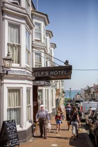 a group of people walking down a street in front of a hotel at Yelf's Hotel in Ryde