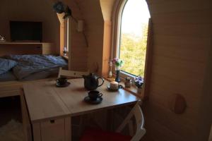 um pequeno quarto com uma mesa e uma janela em Schmidis Igluhuts im Pfaffenwinkel - Tiny House 1 em Apfeldorf