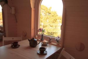 a window in a room with a table with cups and flowers at Schmidis Igluhuts im Pfaffenwinkel - Tiny House 1 in Apfeldorf