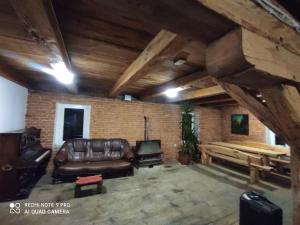 salon ze skórzaną kanapą i drewnianym sufitem w obiekcie Stary Spichlerz w Niemicy w mieście Golczewo