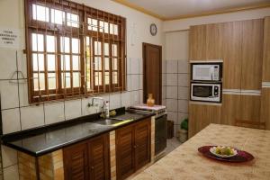 a kitchen with a sink and a microwave at Pousada Arquipélago in Florianópolis